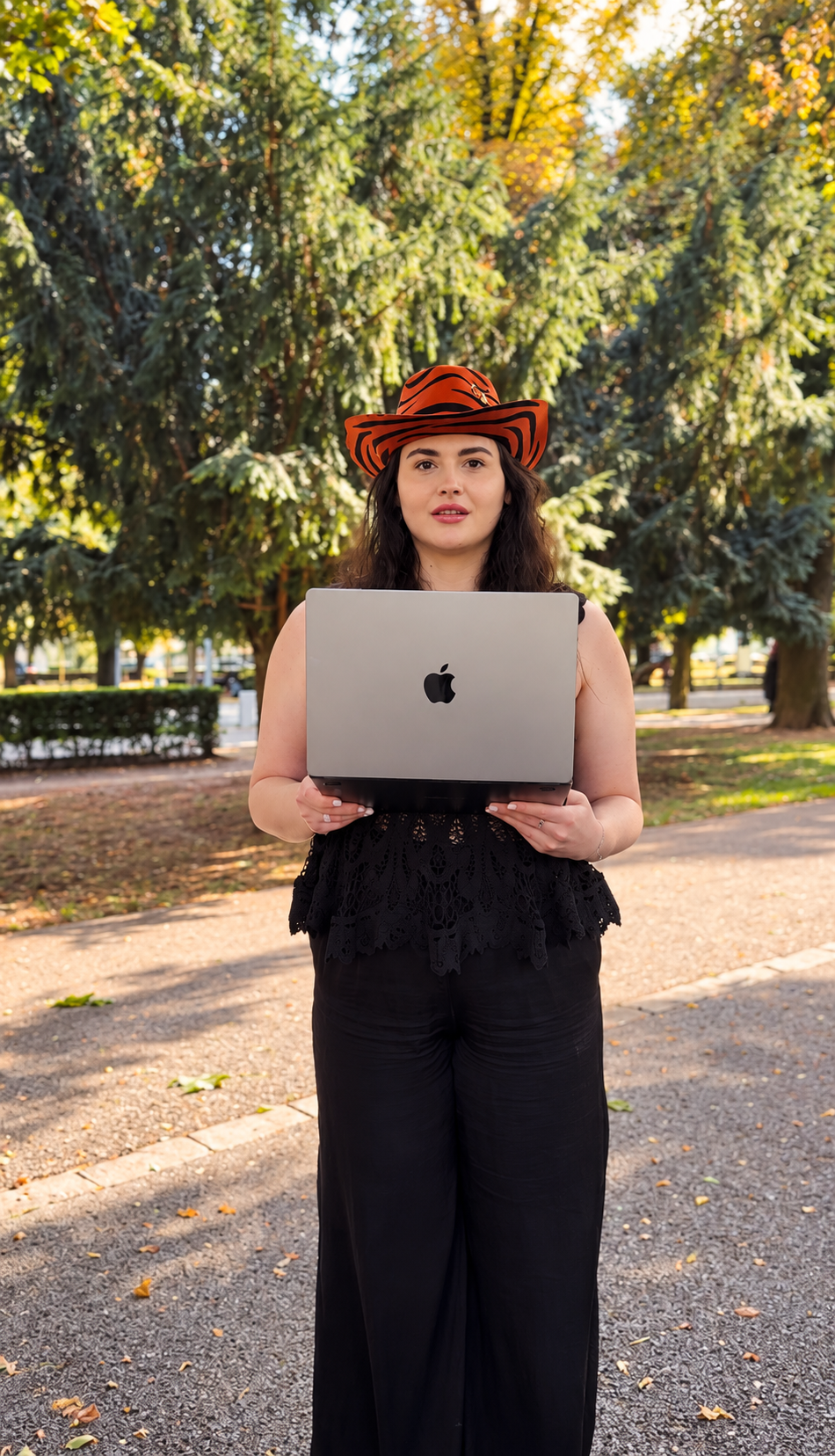 Andreea Chiș, cu laptopul în mână, în parc
